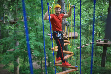 male climber rope park, outdoor activity training, guy, man extreme weekend in the forest