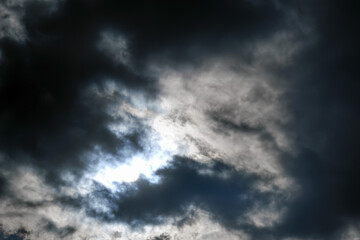 Naklejka na ściany i meble Dramatic dark sky with the sun setting behind black clouds