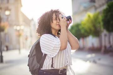 Woman taking photo on camera. Mixed race woman in the city.