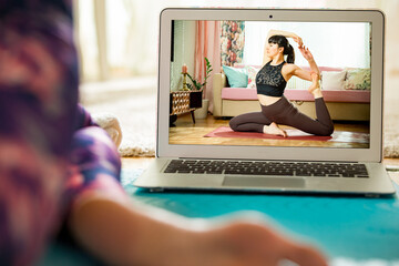 Beautiful fit woman streaming broadcast video blog about yoga and fitness in living room. Healthy...
