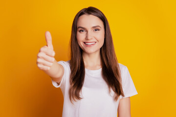 Photo of positive promoter lady show thumb up wear white t-shirt posing on yellow background