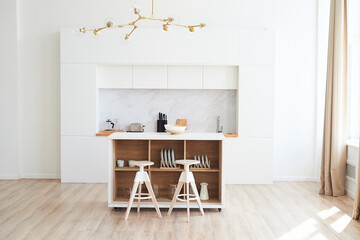 Kitchen in the style of minimalism in white. High countertop with bar stools. A light room in the style of a loft.