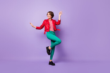 Fototapeta na wymiar Full size photo of young cheerful girl happy positive smile have fun dance look empty space isolated over purple color background