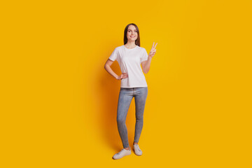 Photo of gorgeous friendly lady show v-sign wear white t-shirt posing on yellow background
