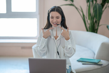 Cute young woman leading online tutorial on taping