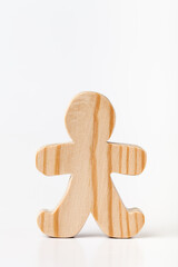Obraz premium A figurine of a toy man carved from solid pine with a hand jigsaw. On a white background