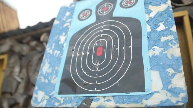 Target for shooting weapons. The shot through the target is like a sieve. Shooting training. At the shooting range. Silhouette of a man on a shooting board. Hole and old target.