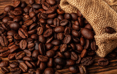 Roasted coffee beans on the old dark wooden background for wallpaper or decor