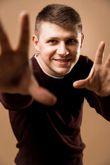 man posing and smiling looking through the hands