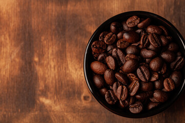 Roasted coffee beans on the old dark wooden background for wallpaper or decor