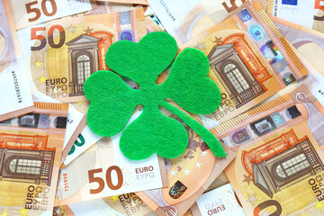 Green felt four leaf clover on 50 fifty euro banknotes background. Euro currency in Europe....