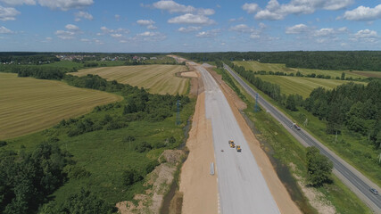 Construction of toll roads in rural areas. Aerial view construction of a new highway next to the old highway.