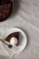 Homemade Chocolate Cake with Ice Cream on a white plate, top view. Flat lay, overhead, from above. Copy space.