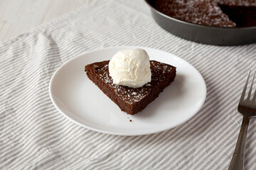 Homemade Chocolate Cake with Ice Cream on a white plate, low angle view.