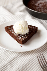 Homemade Chocolate Cake with Ice Cream on a white plate, side view.
