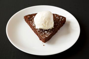 Homemade Chocolate Cake with Ice Cream on a black surface, low angle view.