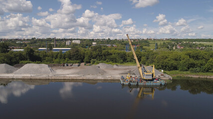 Aerial view large crane an excavator mounted on barge. Excavator on river for unloading and loading sand and rubble.
