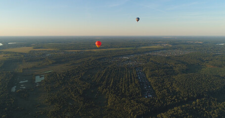 Aerial view Hot air balloons in sky over fields in countryside, beautiful sky and sunset. Aerostat fly over countryside.