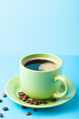 Hot fresh coffee with foam in the green cup on a color background