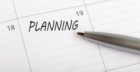 Text PLANNING written on calendar planner to remind you an important appointment with a pen on isolated white background.