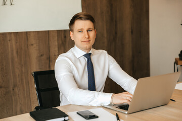 Successful businessman working at a laptop in his office, office work.