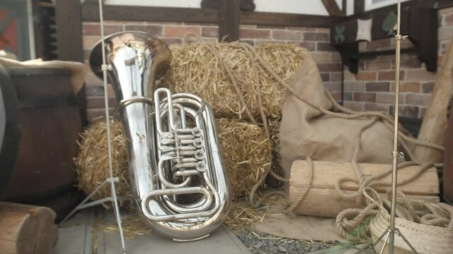 The musician left a brass trumpet musical instrument by a haystack. Preparing for the Oktoberfest celebration. Break for the orchestra. Photo zone with musical instruments and sheaves of hay. 