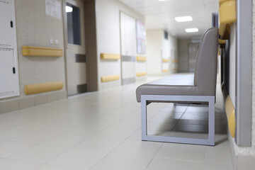Gray couch standing in empty hospital hallway