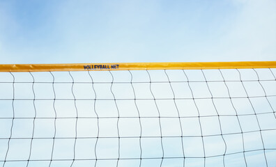 beach volleyball net against the sunny sky background in the summertime.