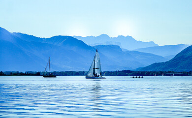 sailing boat on the lake with mountains in the background