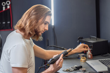 Attentive man looking at microcircuit at table