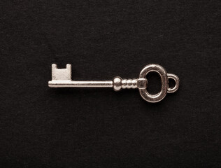 Decorative metal key on the empty black background