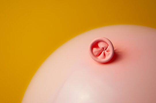 An image of a pink balloon on a yellow background. Metaphor prevention of hemorrhoids, anus hygiene, proctology, bowel health. 