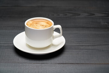 Cup of espresso coffee on dark wooden background