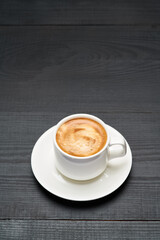 Cup of espresso coffee on dark wooden background
