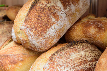 Large loaves of bread. Fried crust, white dusting. Angle view. Homemade food concept.