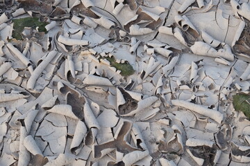 Flakes of dried mud as a background. Dry barren soil texture.