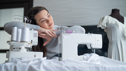 Young caucasian woman sews at home