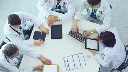 Medical team sitting and discussing at table, top view