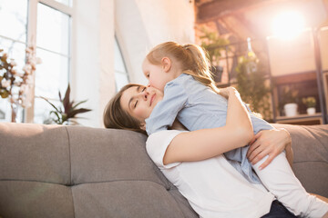 Family time. Mother and daughter having time together at home, look happy and sincere