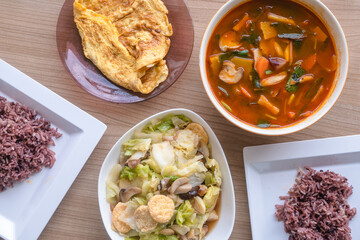 Hot and sour Thai Tom yam soup eat and omelet and stir fried chinese cabbage eat with steam brown rice