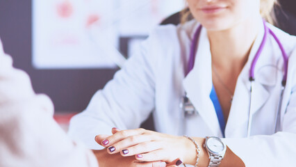 Woman doctor helping senior holding hand in hospital