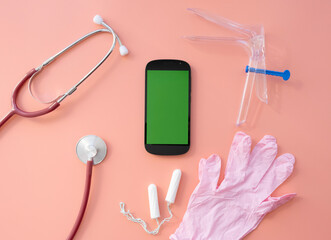 a layout with medical instruments, tampons, and a phone on a pink background.