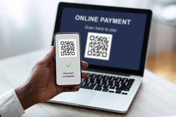 Unrecognizable businessman scanning bar code by smartphone from laptop