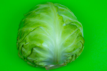 Fototapeta premium Green cabbage on the green background. Close up. Macro photo. Minimalism, original beautiful food photo.