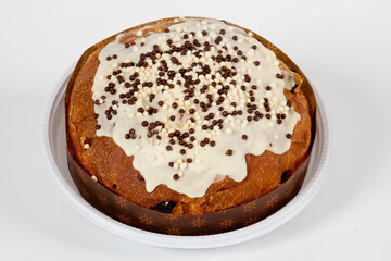 Homemade cake with vanilla icing and chocolate sprinkles on white background seen from above