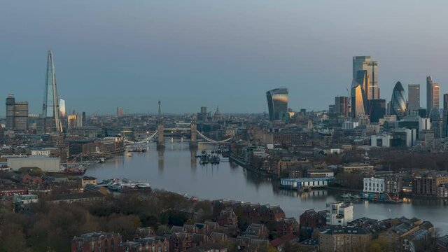 Elevated sunrise to day time lapse view of the skyline of London with Tower Bridge, Thames river and the skyscrapers of the City, United Kingdom
