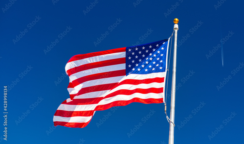 Sticker Waving American Flag with flying aircraft and blue sky in the background. Travel and holiday concept