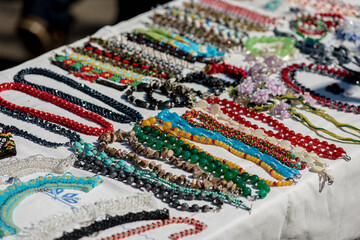 Different ethnic bright necklaces for sale at street market, small business, outdoor street sale autumn fair amid coronavirus pandemic lockdown