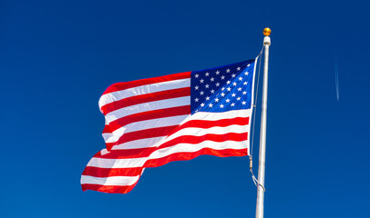 Waving American Flag with flying aircraft and blue sky in the background. Travel and holiday concept