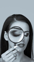 Young beautiful woman looking through magnifying glass. aspect ratio convenient for use in stories....